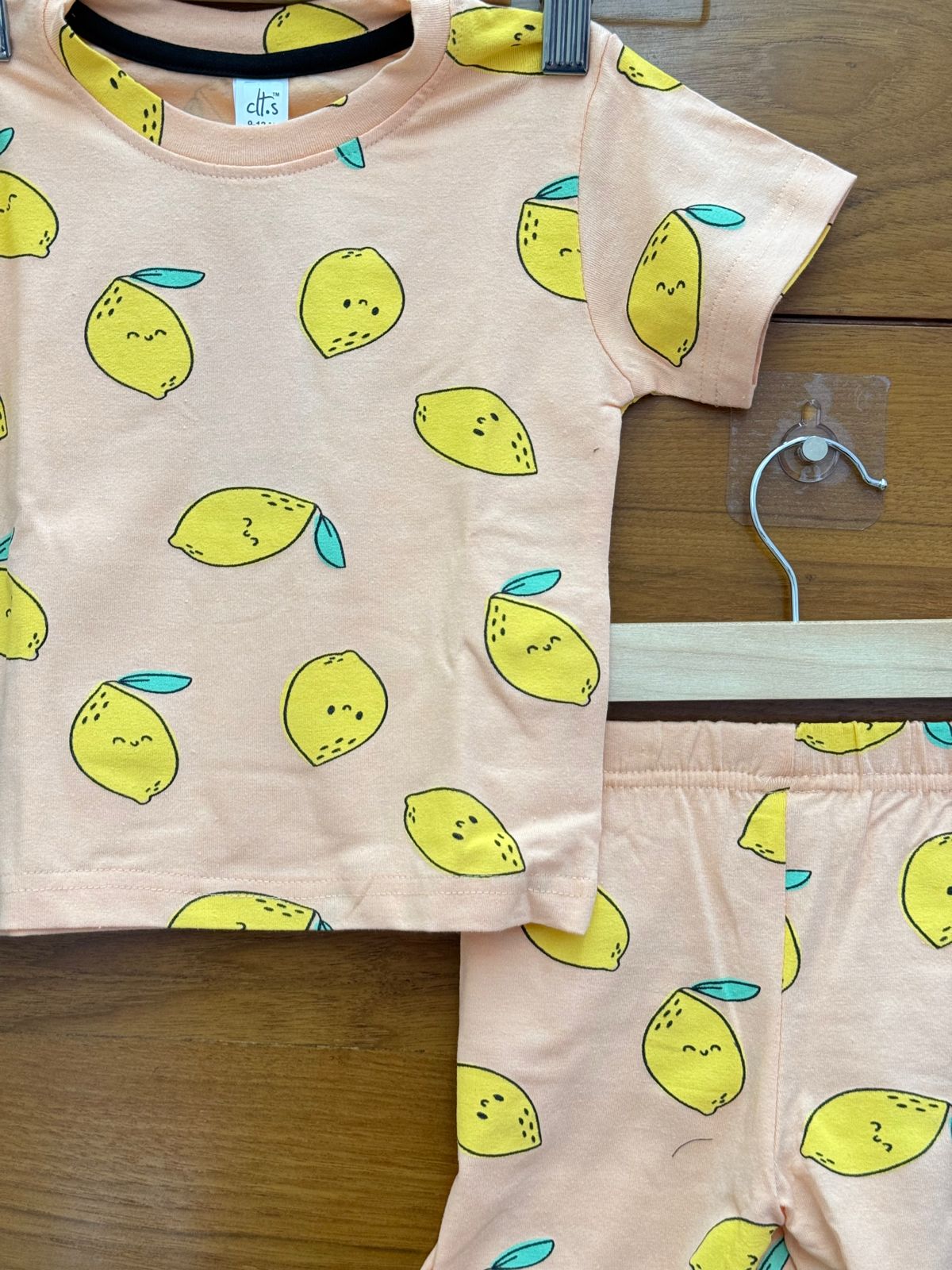 This is a cute and playful toddler clothing set featuring a peach-colored short-sleeve t-shirt and matching shorts.